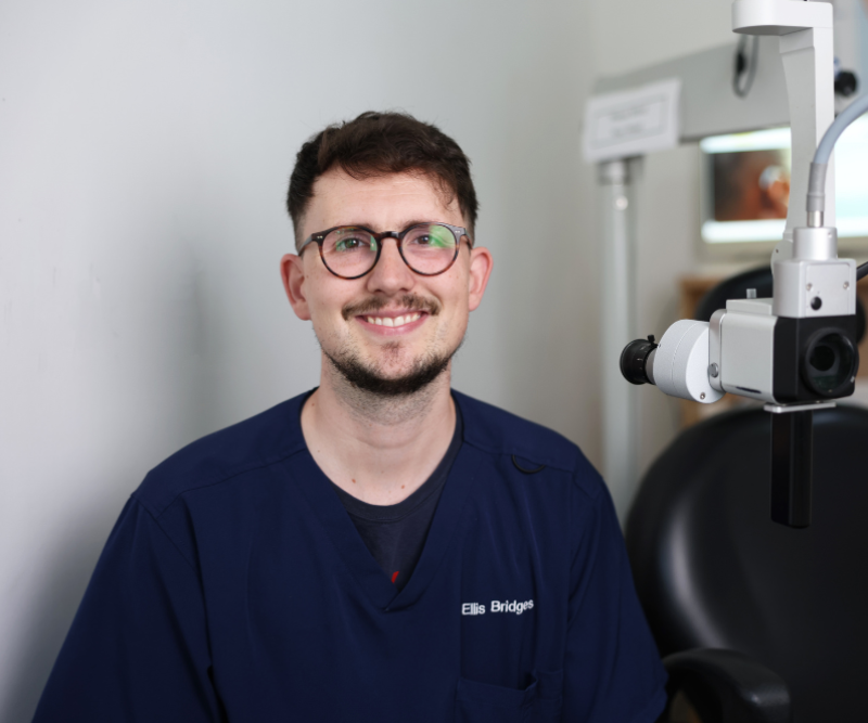Earwax Removal clinician Ellis sitting and smiling at House of Hearing Lichfield.