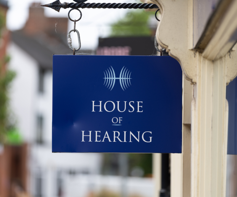 Hanging branded sign outside House of Hearing Lichfield.